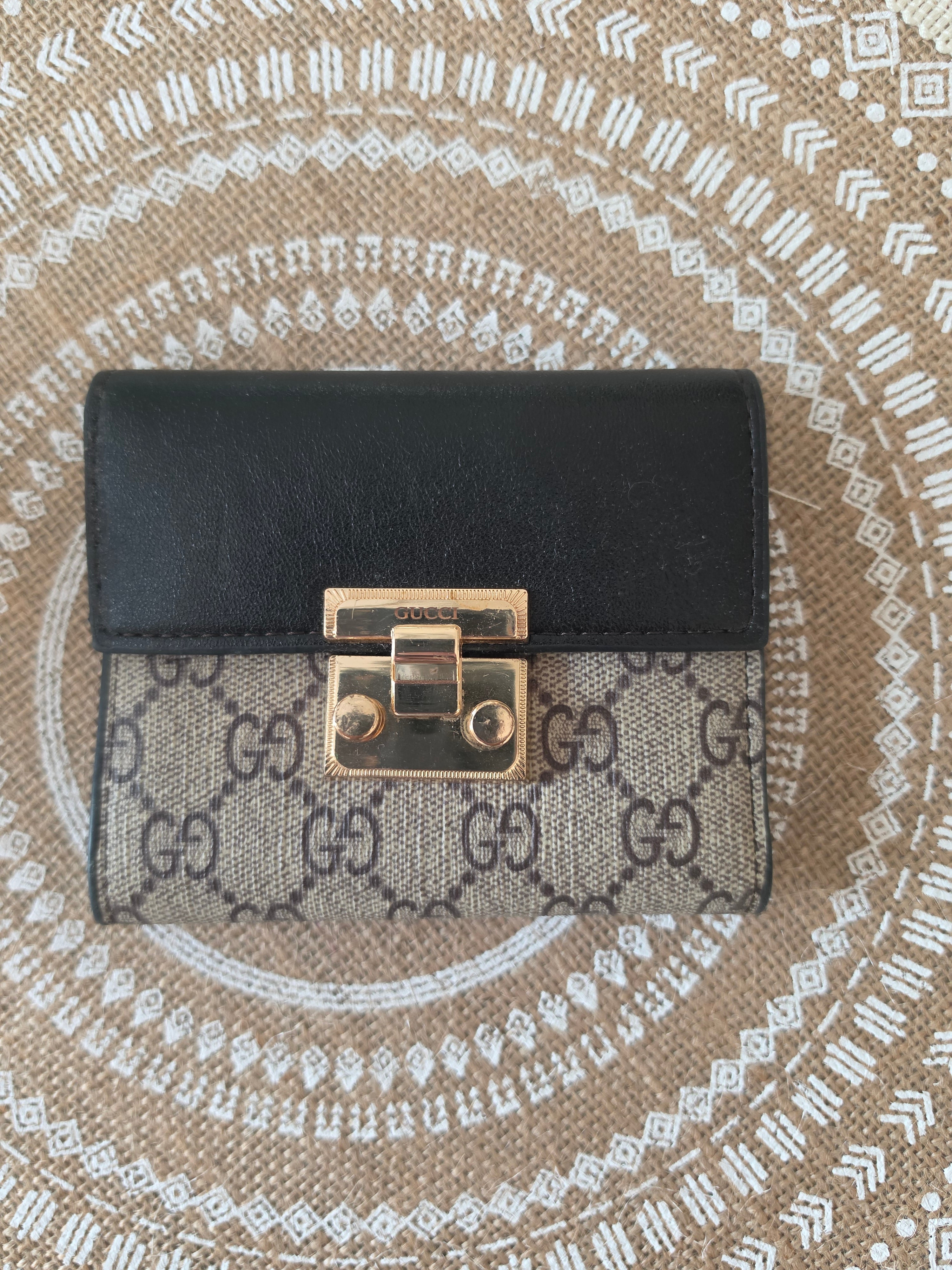Gucci GG Supreme compact wallet — front with gold padlock closure