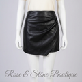 Illustrative mannequin styling of Dynamite black faux-leather ruched mini skirt
