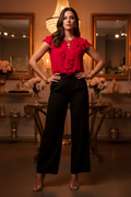 Scarlet Flutter Blouse — styled with wide-leg black trousers and gold heels