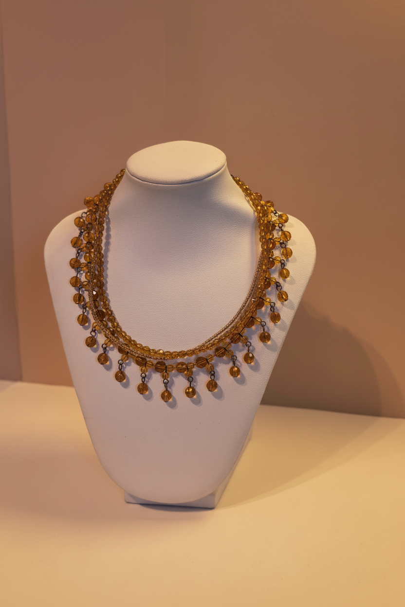 Multi-strand amber glass bead fringe necklace on white velvet bust, Rose & Stōne Boutique