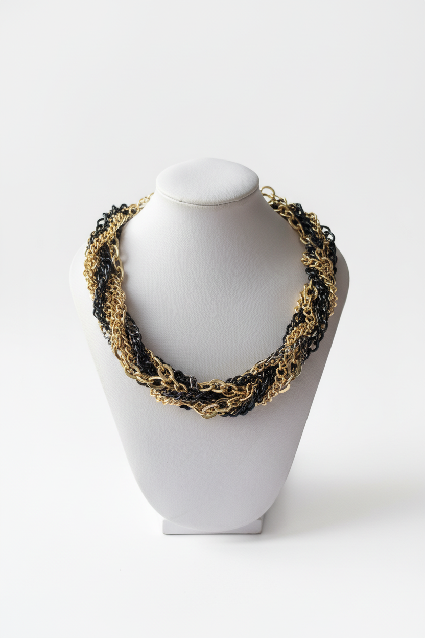 Chunky gold and black twisted chain statement necklace on white jewellery bust, no orange